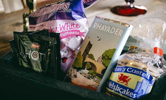 Welcome hamper with marshmallows, welsh cakes, chocolate, hot chocolate, tea, coffee and sugar sachets and milk in the fridge.